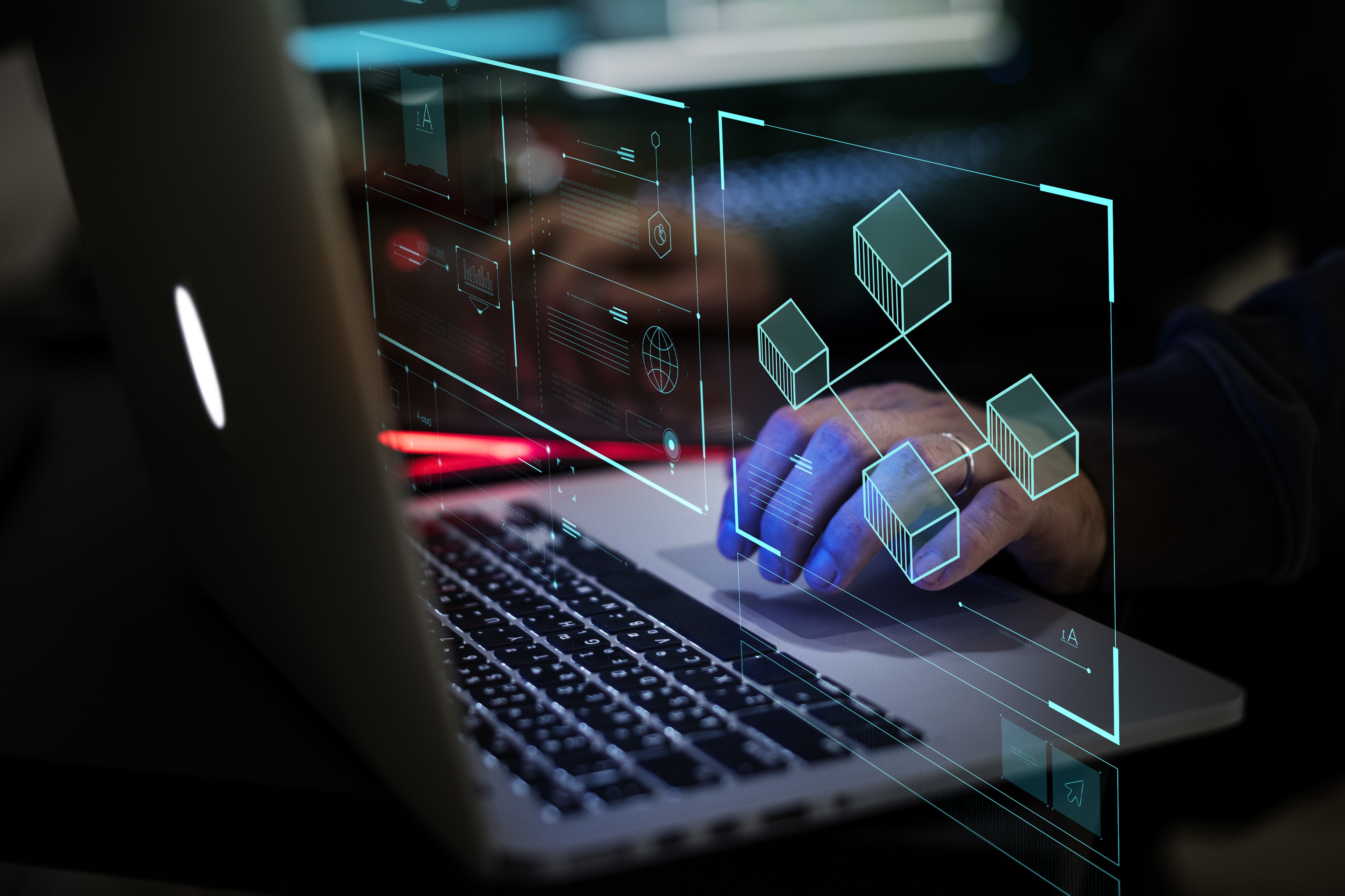 Hands typing on a laptop keyboard with digital holograms of database icons and graphs. Blue and red lights create a tech atmosphere.