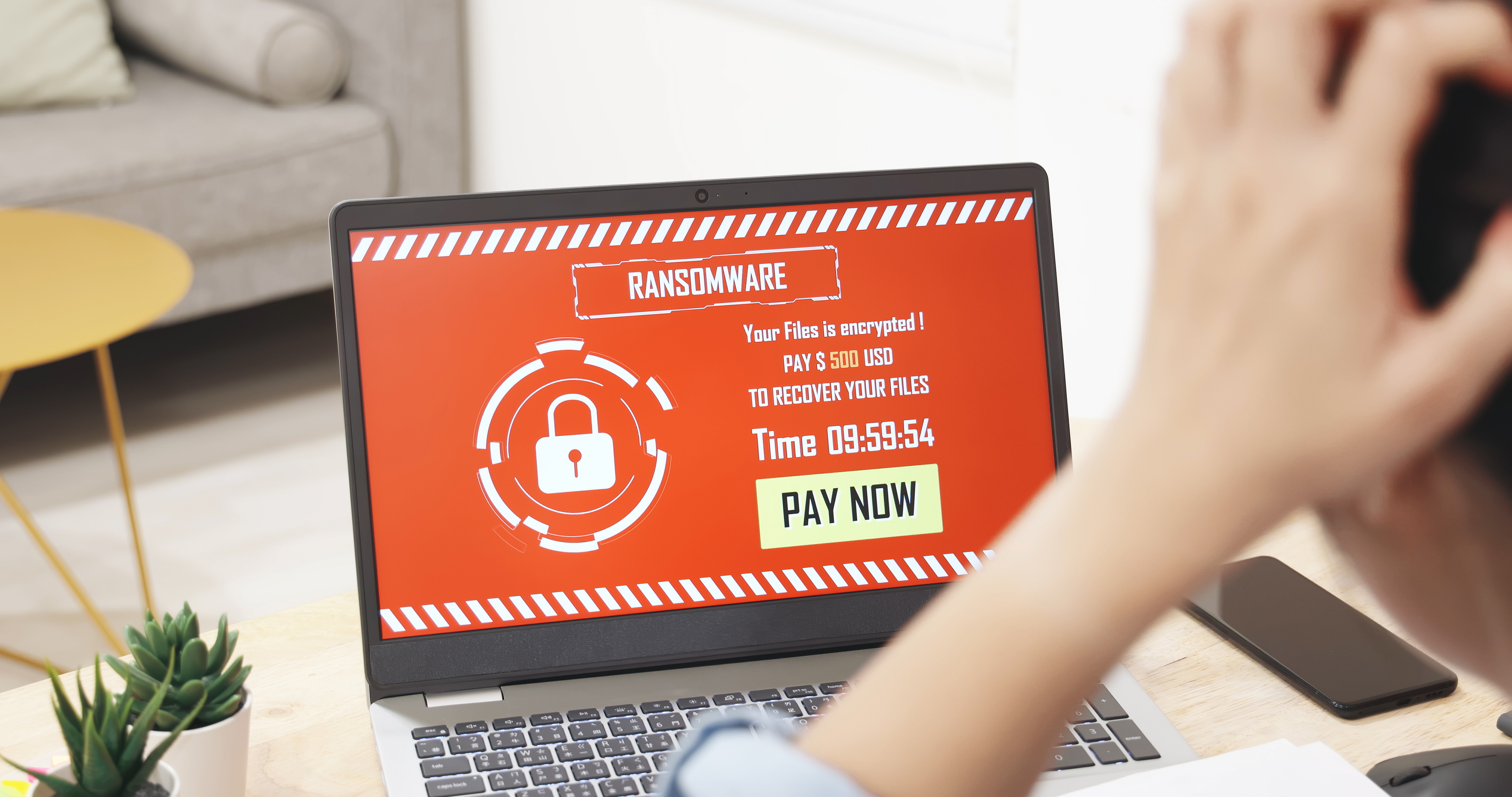 worried asian young woman looking at laptop computer with ransomware attack words on the screen at home